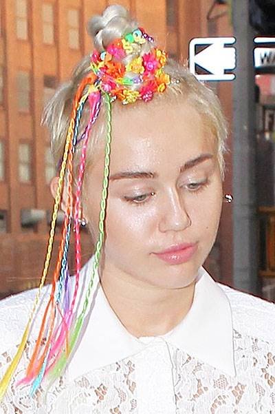 Miley Cyrus with funky beads in her hair and interesting outfit