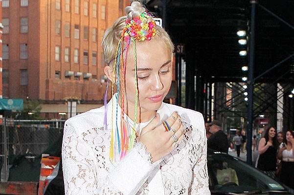 Miley Cyrus with funky beads in her hair and interesting outfit